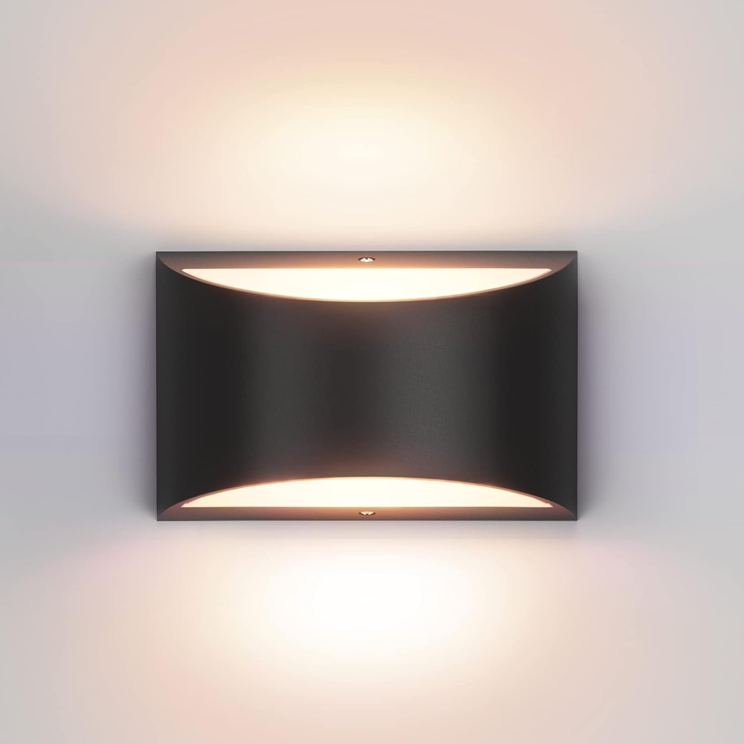 Black LED up/down wall sconce mounted on a white wall showing warm up and down illumination
