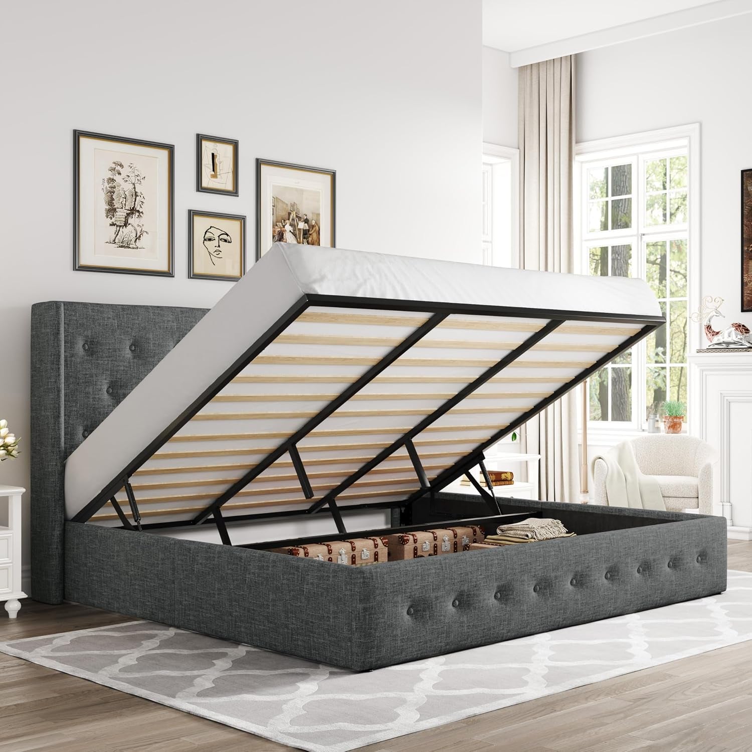 Three-quarter view of a darker charcoal-gray upholstered storage bed with mattress raised to show the storage area.
