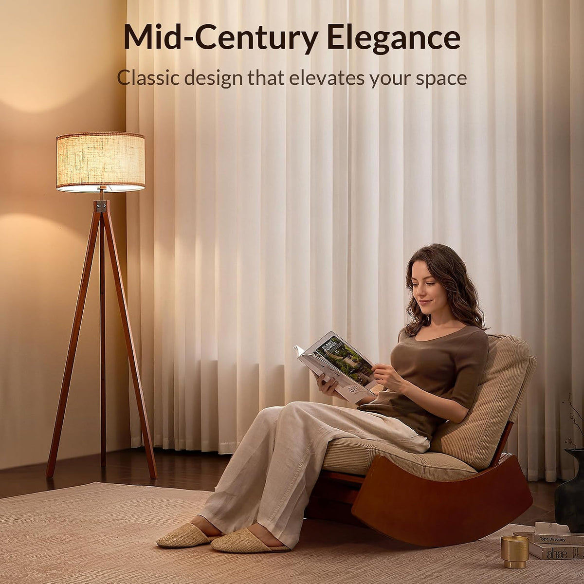 Tripod floor lamp with linen shade lit in a cozy living room corner beside a seated woman reading