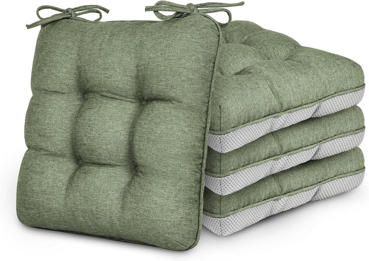 Stack of four sage green tufted chair cushions with ties, one cushion angled against the stack