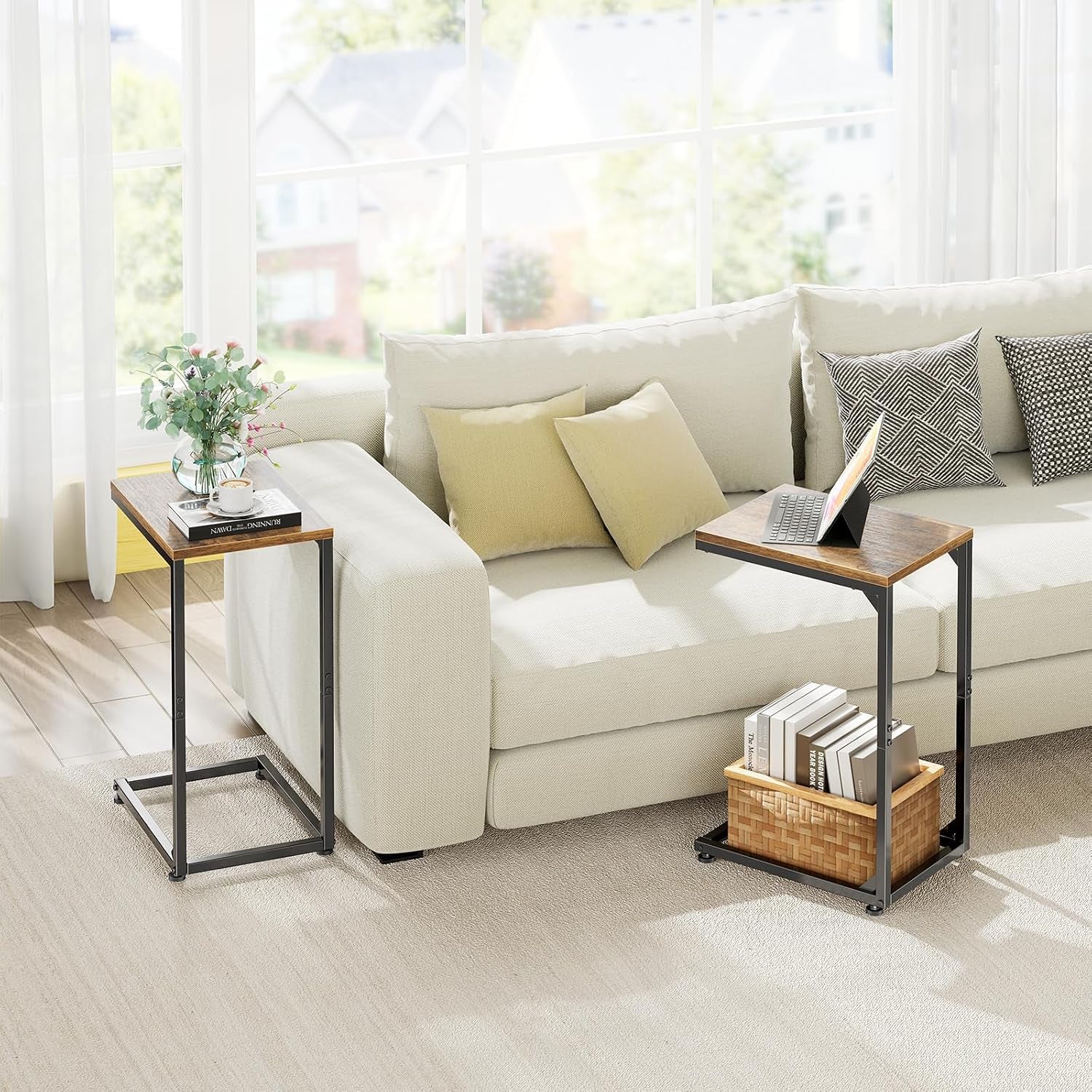 Living room scene with two C-shaped tables next to a light sofa, one holding a laptop and one a vase.