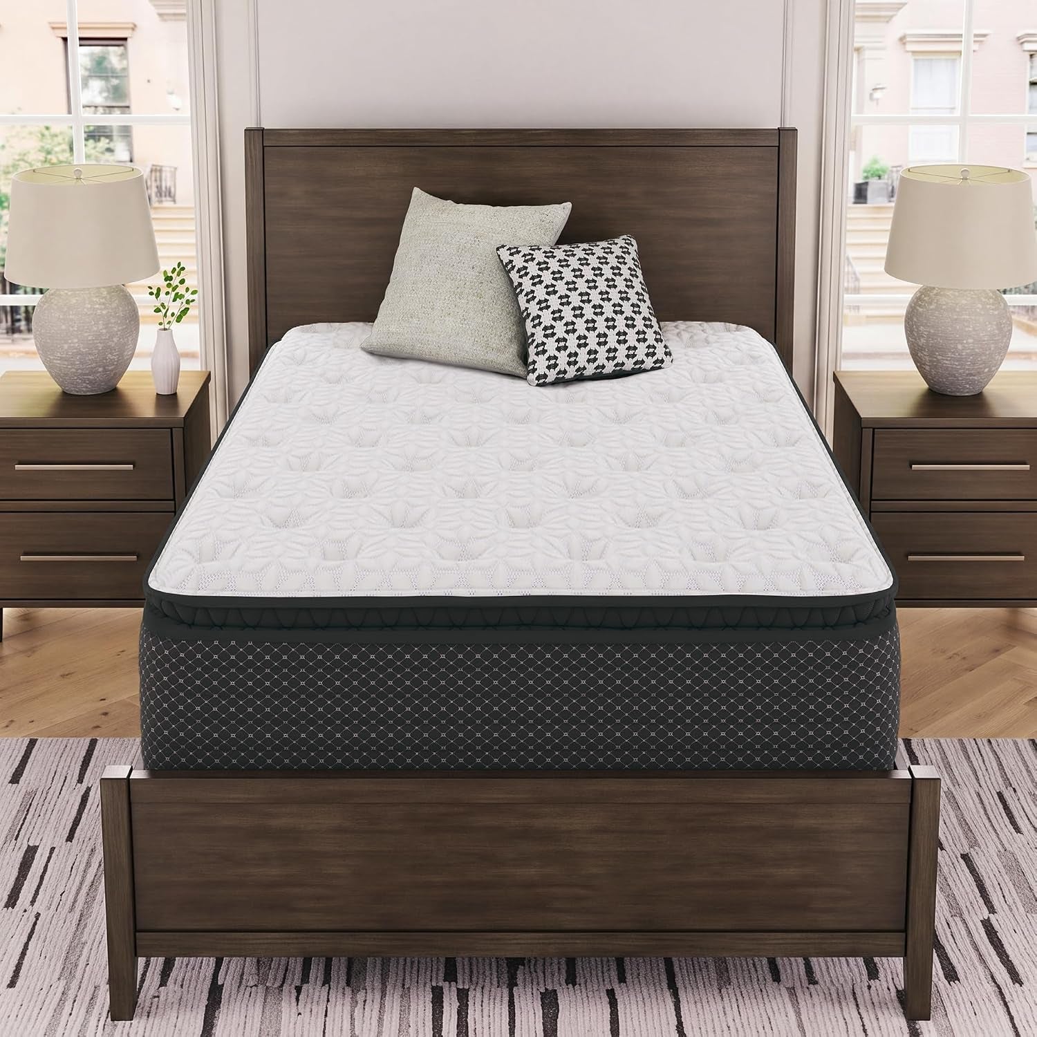 White quilted pillow-top hybrid mattress on a wood bed frame, front angled view in a styled bedroom