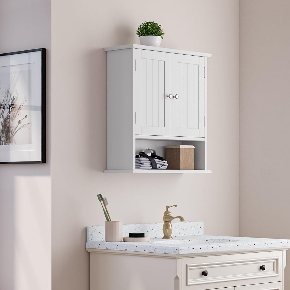 White medicine cabinet hung above a sink and vanity, styled with a small plant on top and folded towels inside.