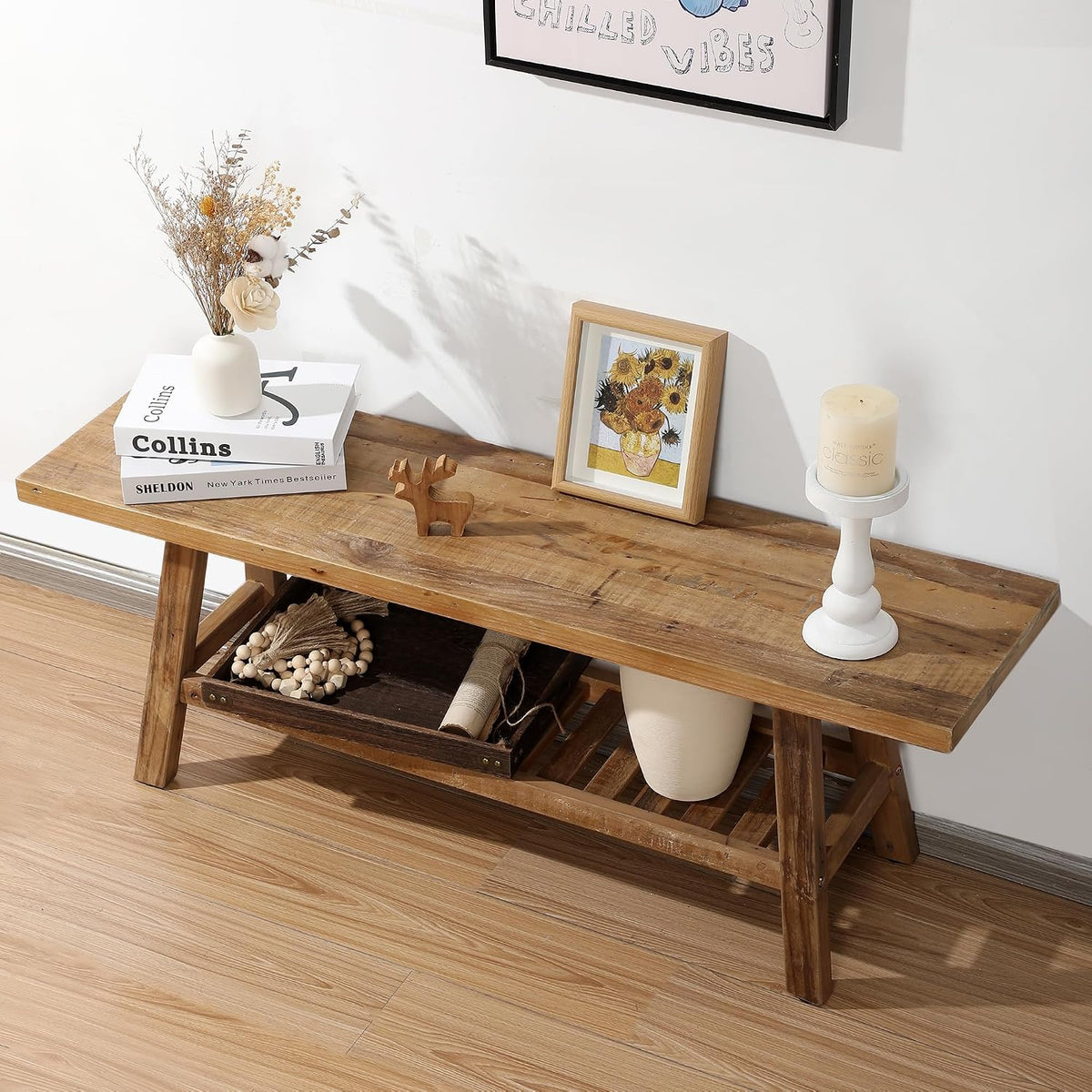Reclaimed wood bench with decorative books, framed print and candle on top, front view of shelf storage.