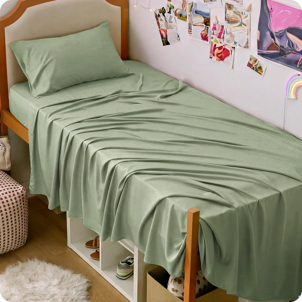 Angled view of a twin bed with sage green sheets, pillow and open cubby storage visible beneath the frame.