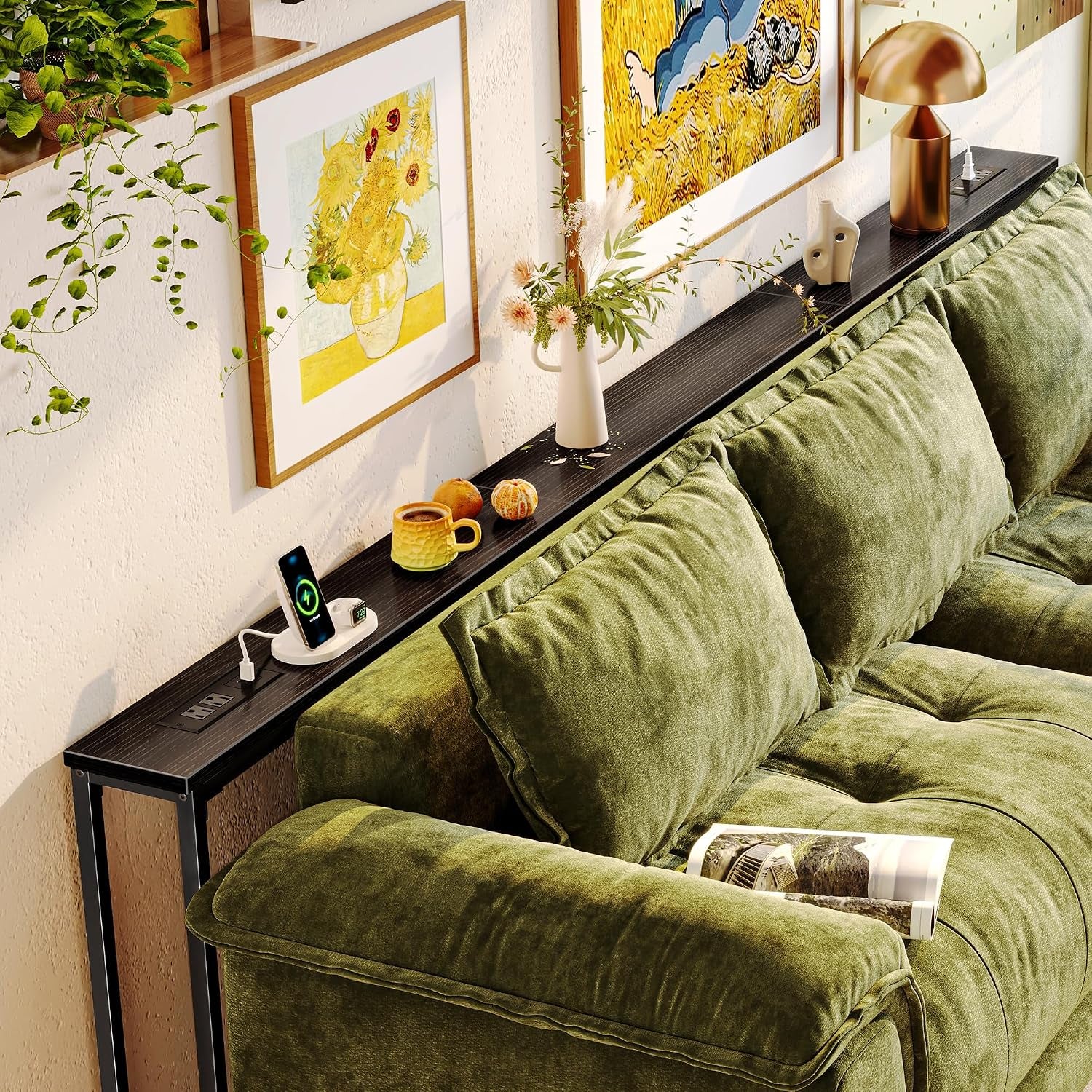Slim console table spanning a sectional sofa with framed art above and accessories on the tabletop