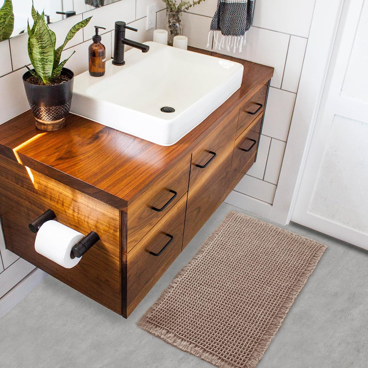 Taupe waffle bath mat beside a wooden bathroom vanity