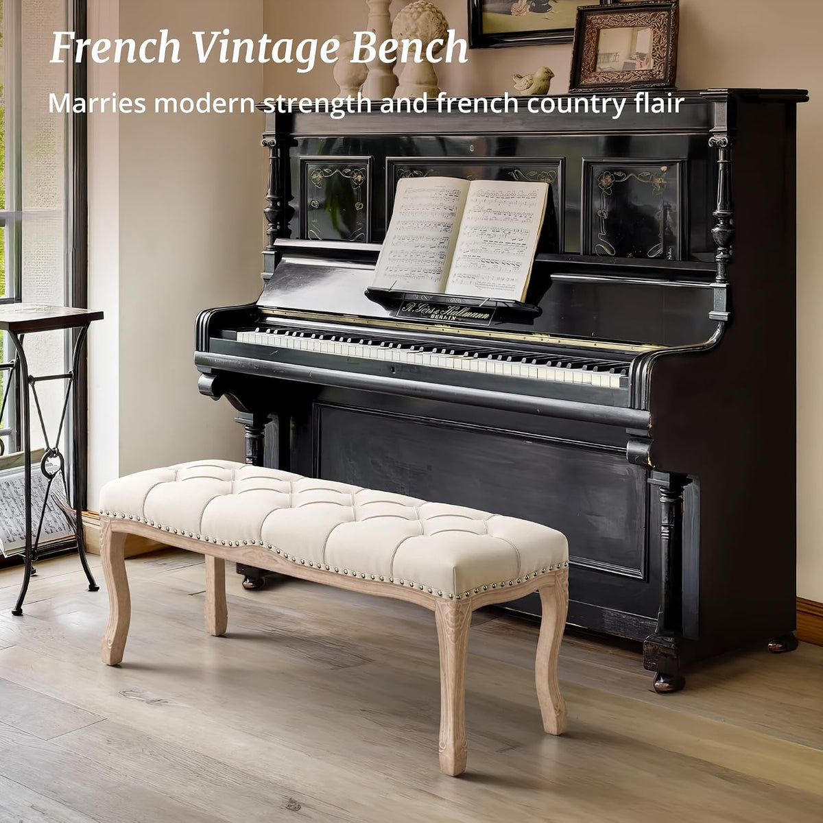 Beige tufted bench placed in front of a black upright piano on light wood flooring, side view.