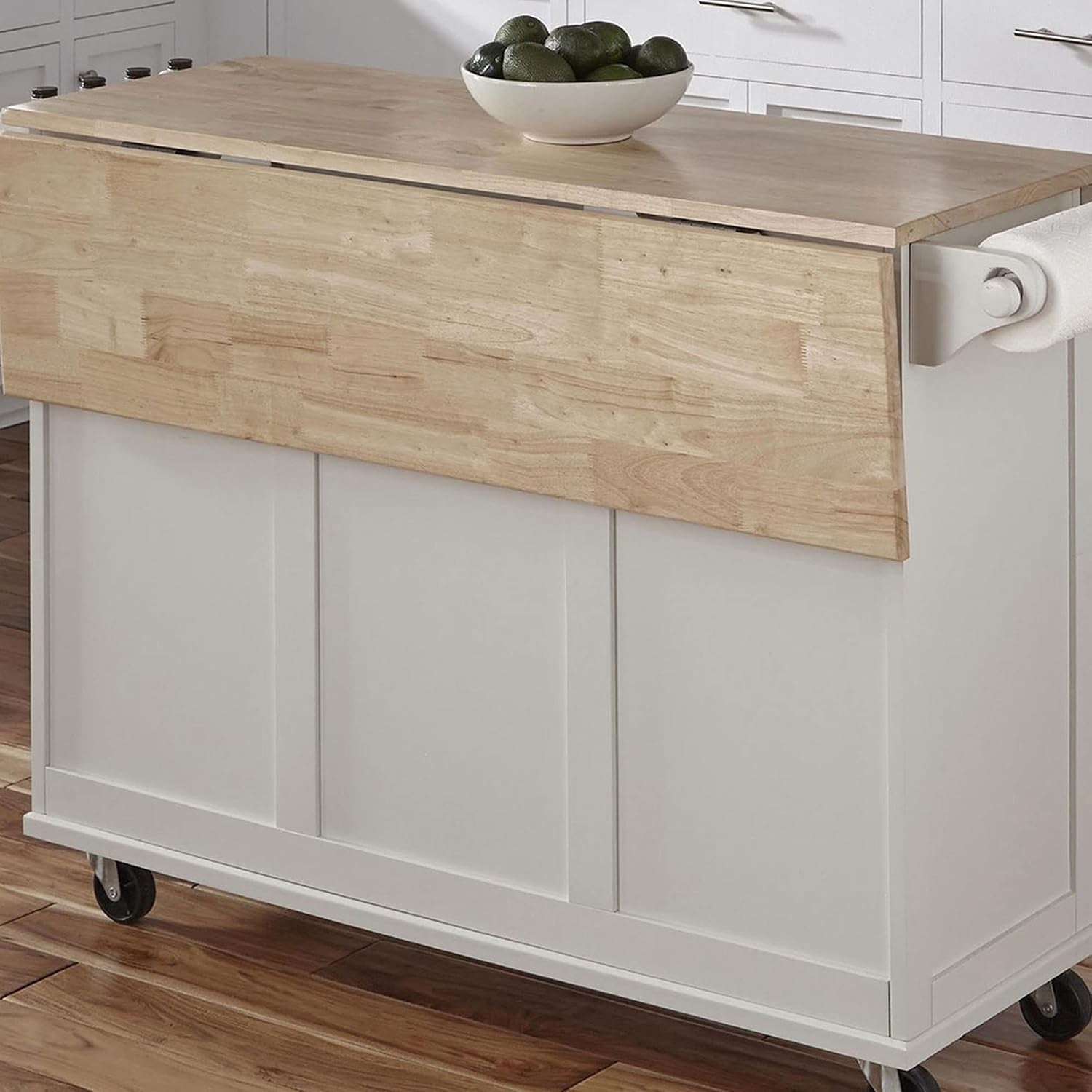 Close view of the island's wood drop leaf folded down over the white base, showing paper-towel holder and caster