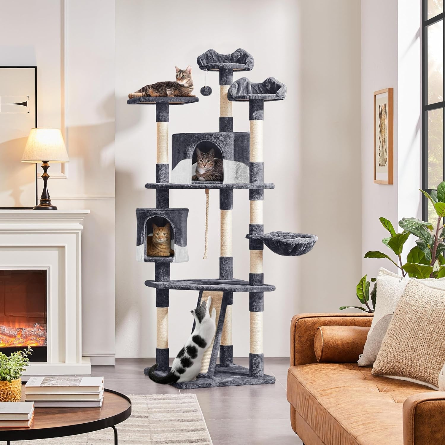 Dark gray cat tree in a living room setting with multiple cats on perches and in condos