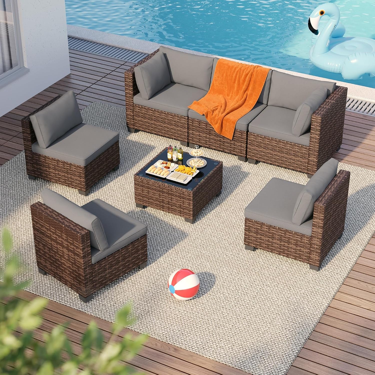 Aerial view of the rattan sectional arranged around the tempered glass coffee table beside a pool