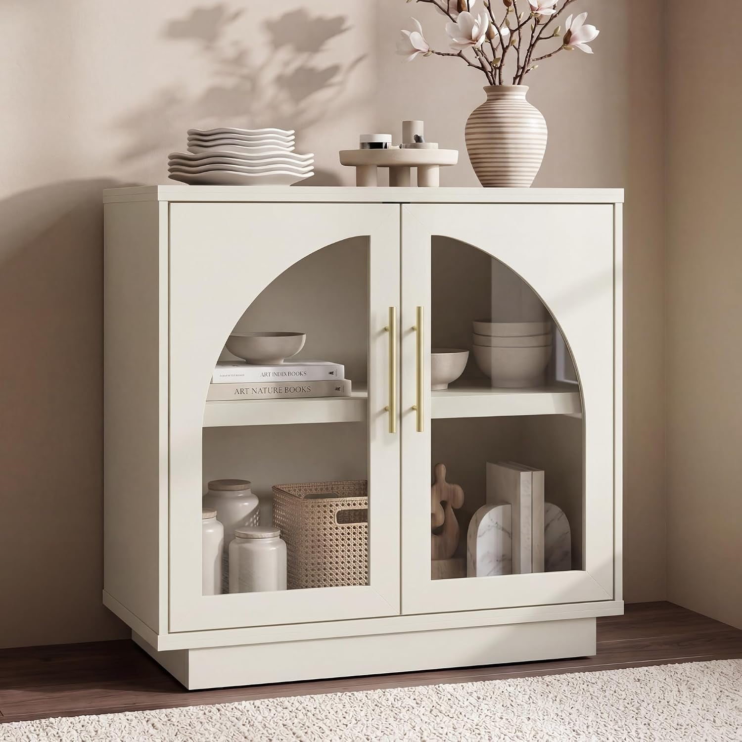 Three-quarter view of a two-door glass-front cabinet showing interior shelves with jars, a woven basket and a striped vase