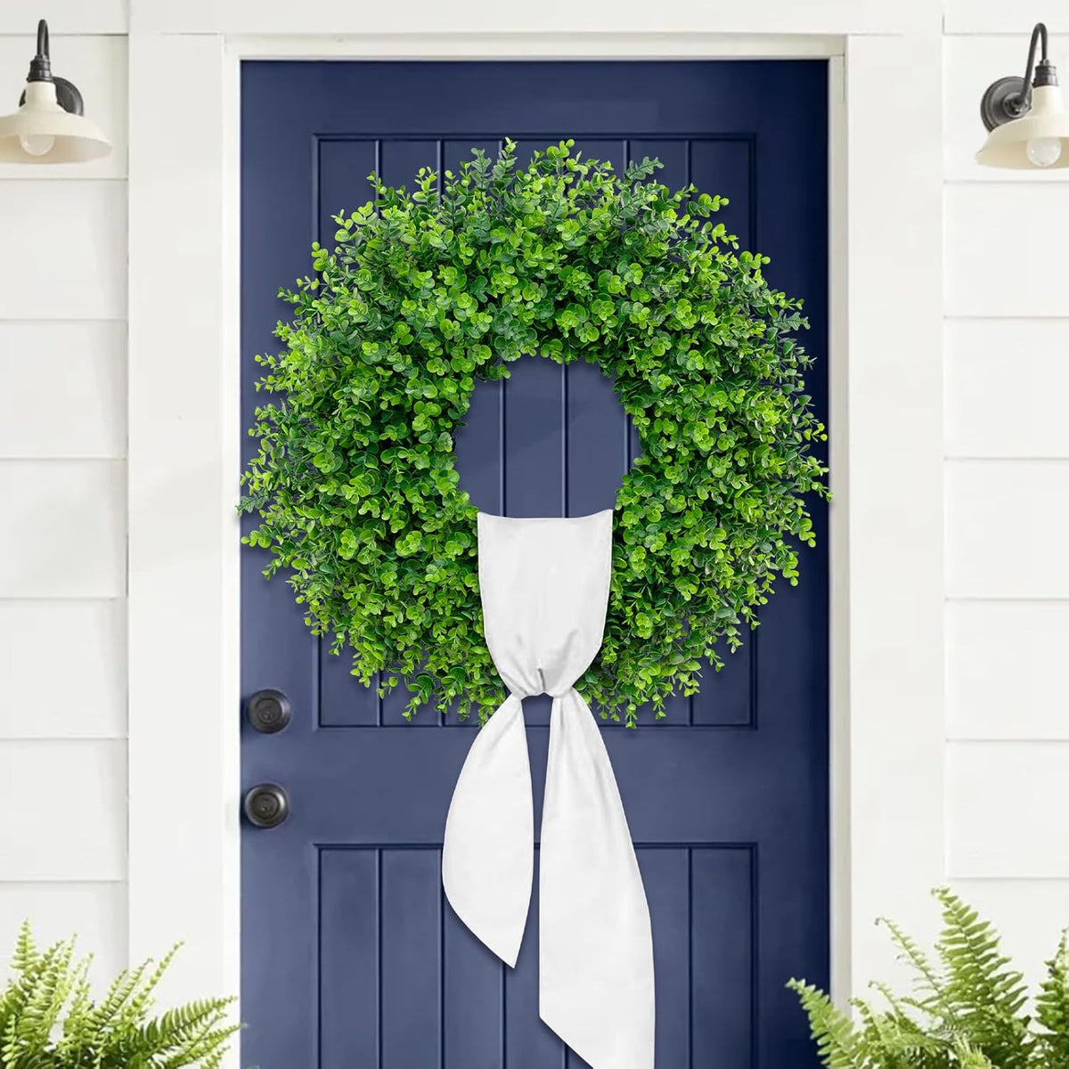 Full wreath centered on a navy blue front door with hanging sash