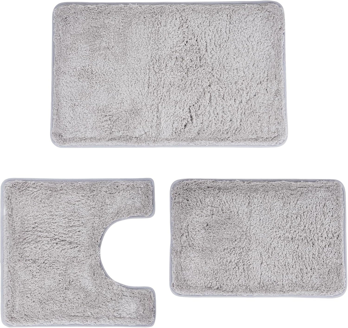 Flat lay of three light gray plush bathroom mats: large rectangle, U-shaped toilet rug, and small rectangular mat.