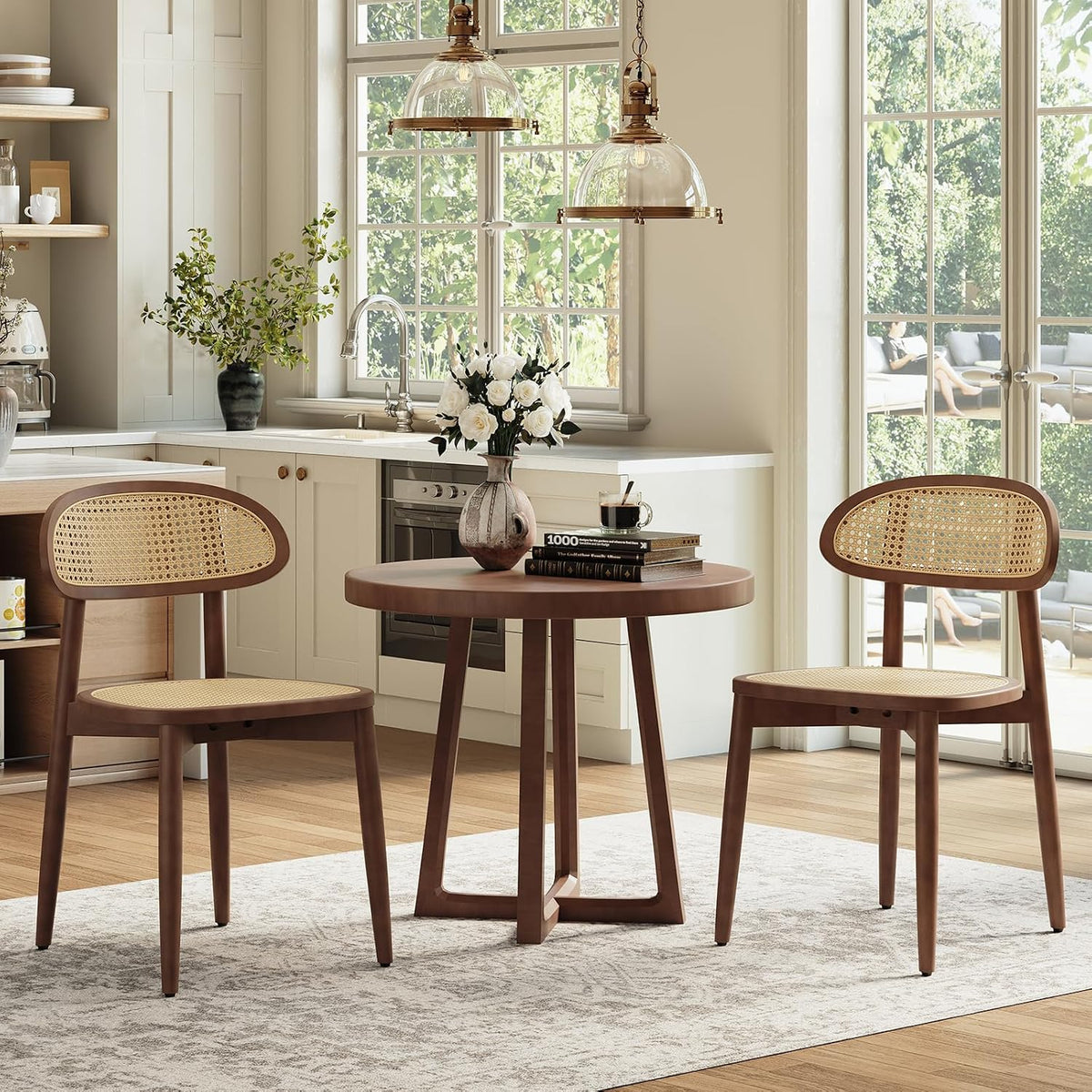 Two walnut-finish rattan-back dining chairs beside a round wood table in a bright kitchen.