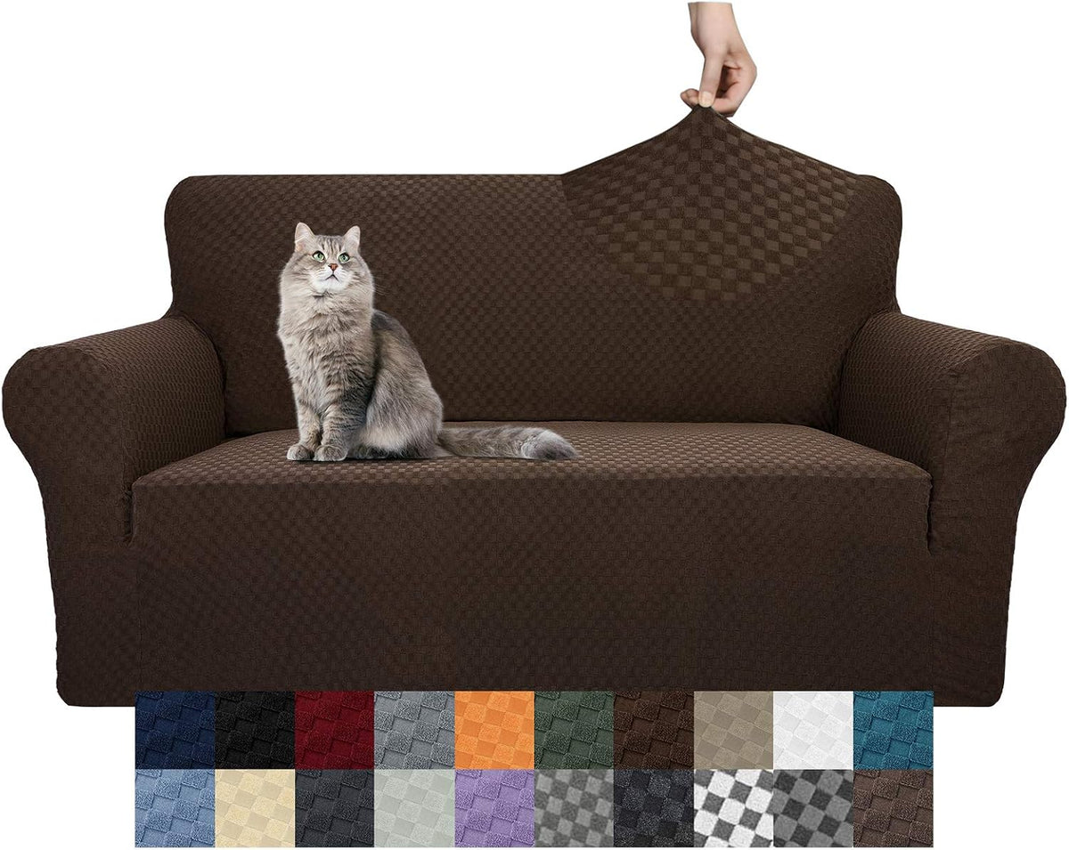 Front view of a dark brown stretch sofa cover fitted on an armchair with a cat perched on the seat