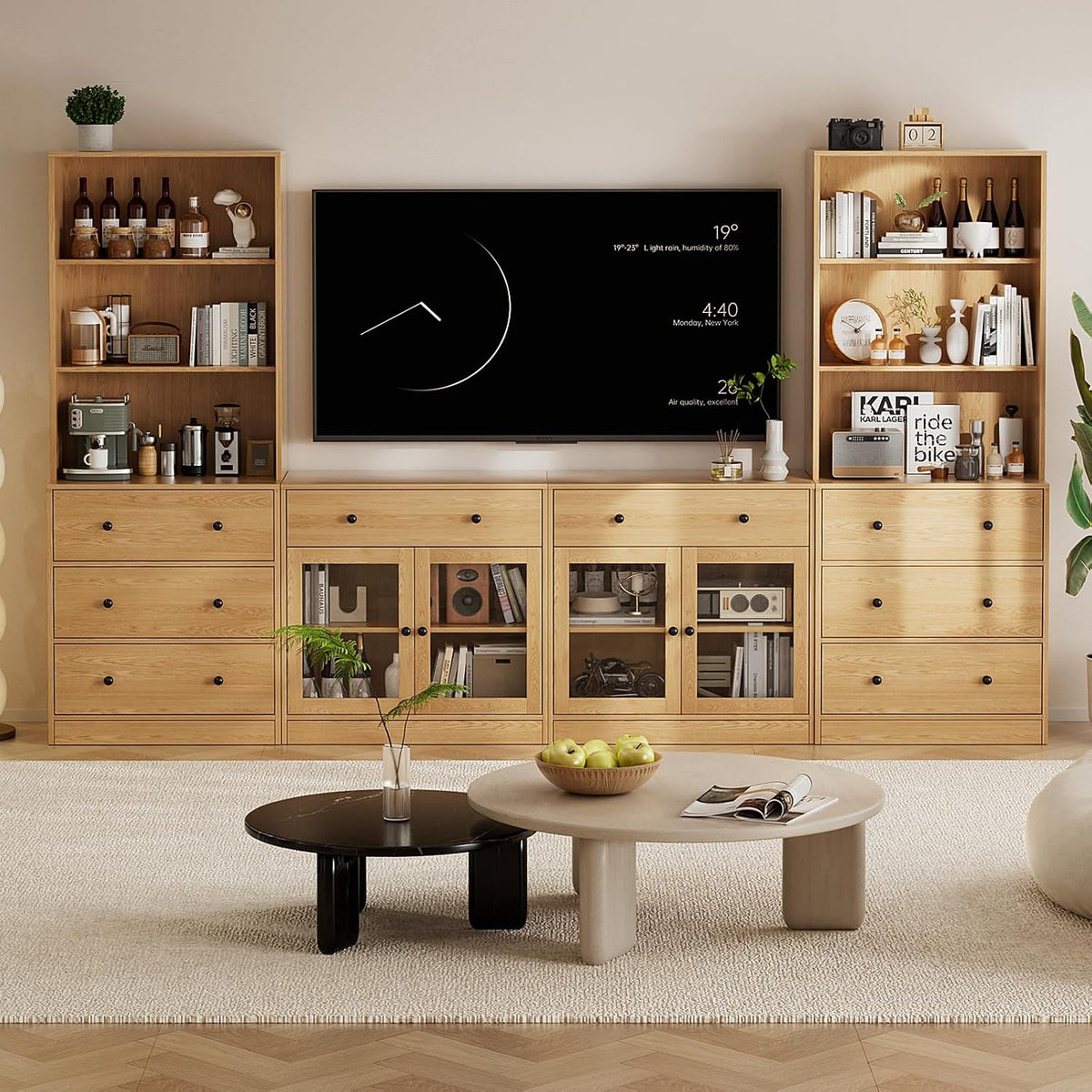 Full living-room view of a natural wood 4-piece modular TV stand and tall bookcases with a wall-mounted TV.