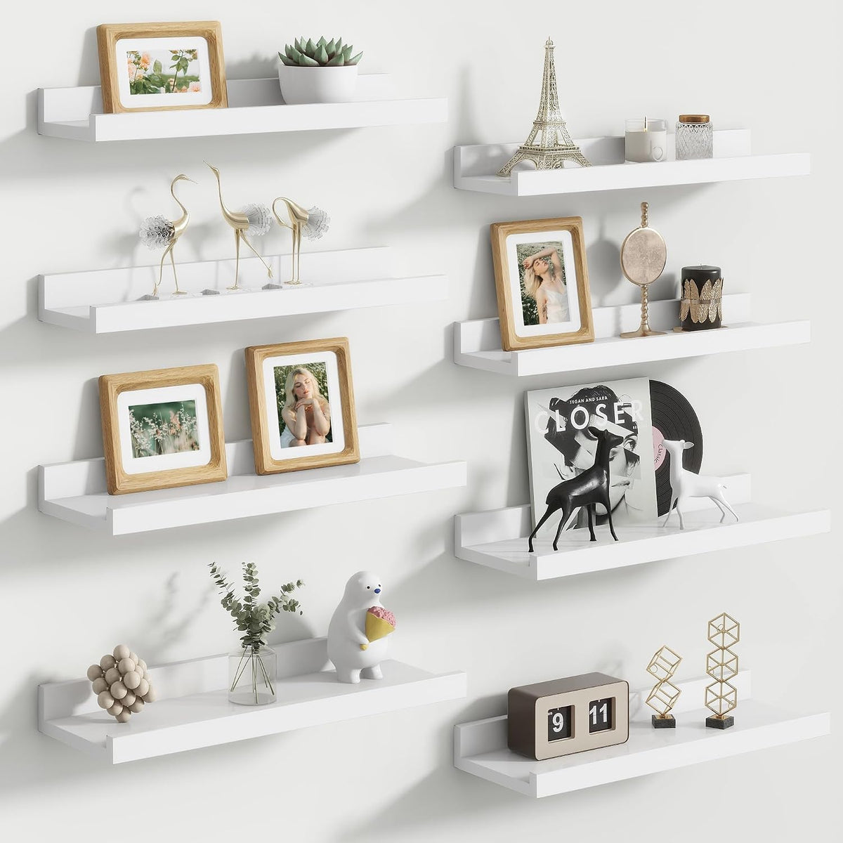 Cluster of small white floating ledges arranged with frames, figurines and a clock