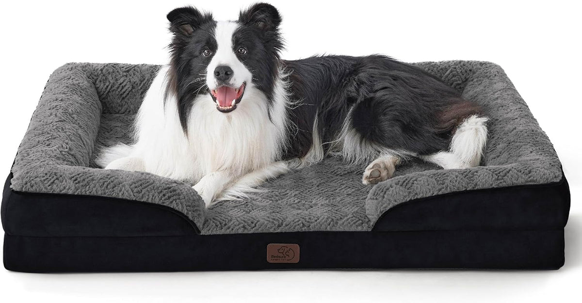 Border collie lying in a dark gray plush bolstered rectangular pet bed with black base.