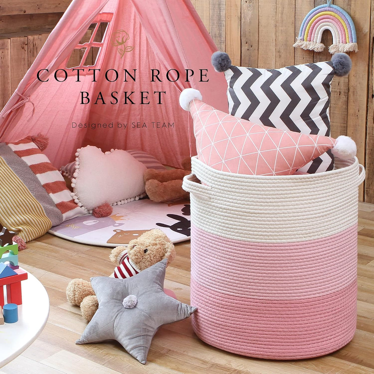 Pink tri‑tone cotton rope basket in a children's playroom setting holding pillows and toys
