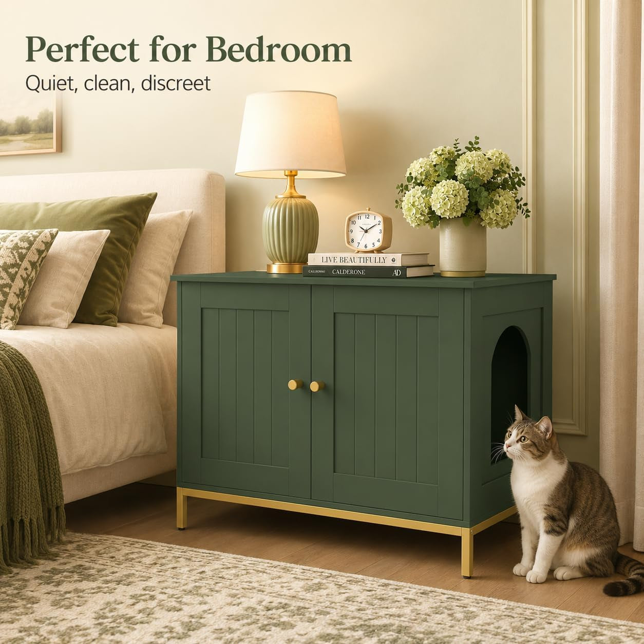 Green cabinet styled as a bedside table with lamp, books and flowers on top and a cat sitting beside the arched side opening.