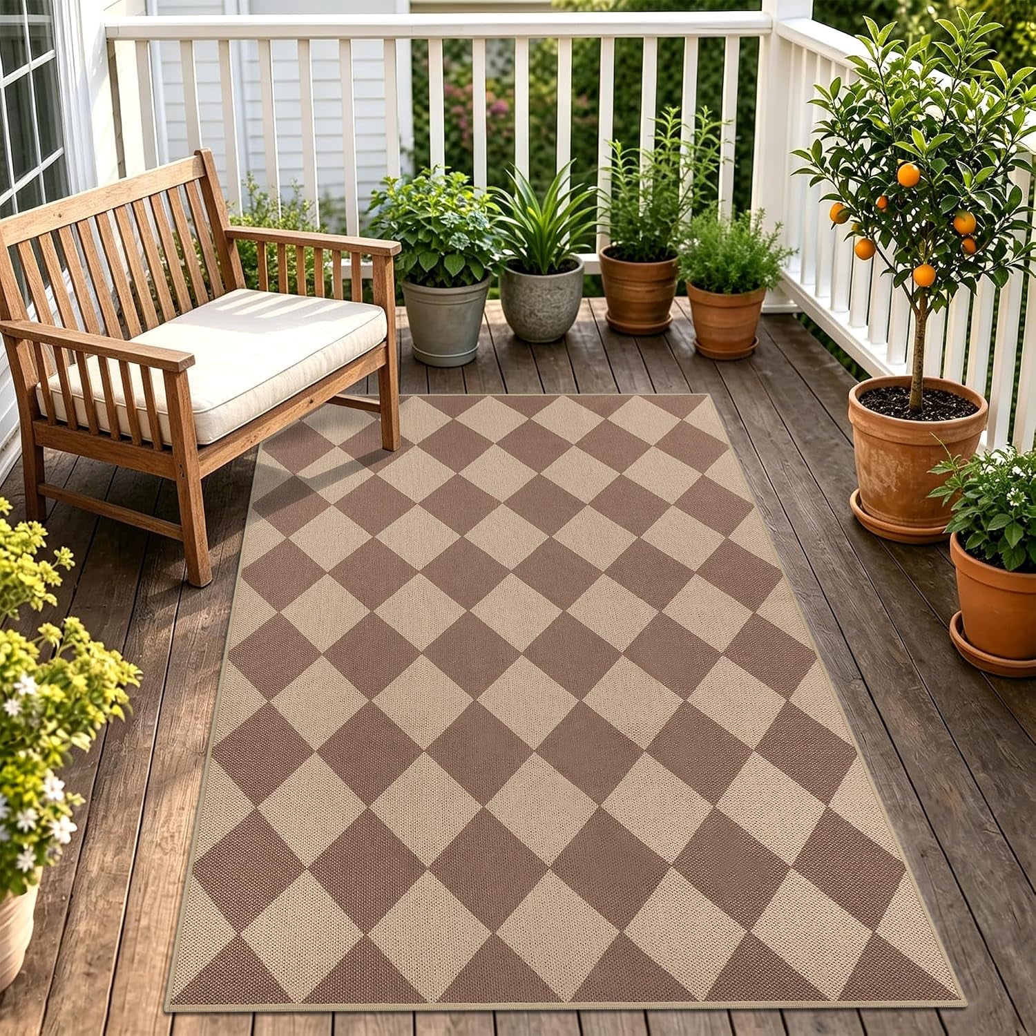 Diamond-check patterned rug on a wooden porch beside a cushioned bench and several potted plants.