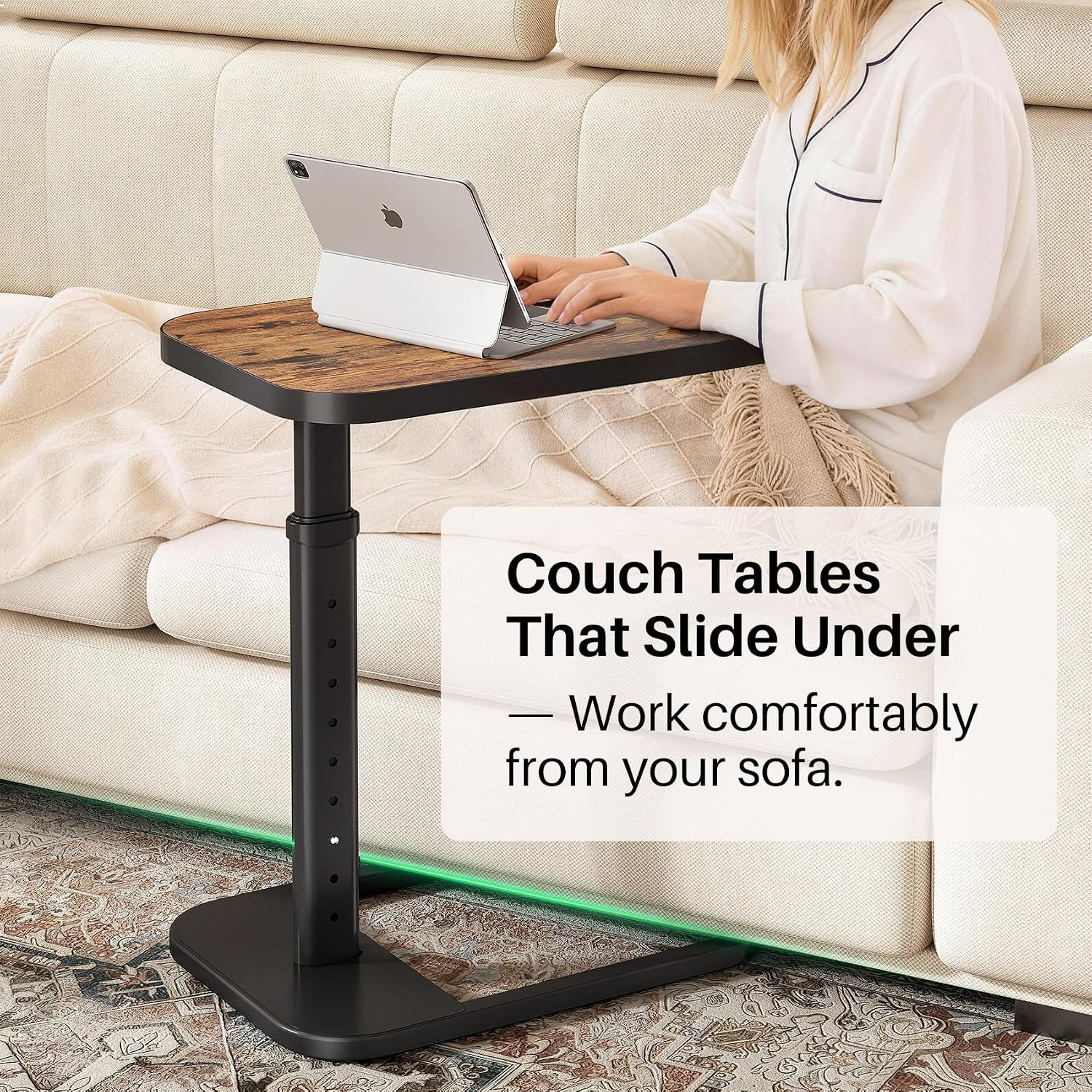 Woman using the adjustable C-shaped table as a laptop stand while seated on a sofa