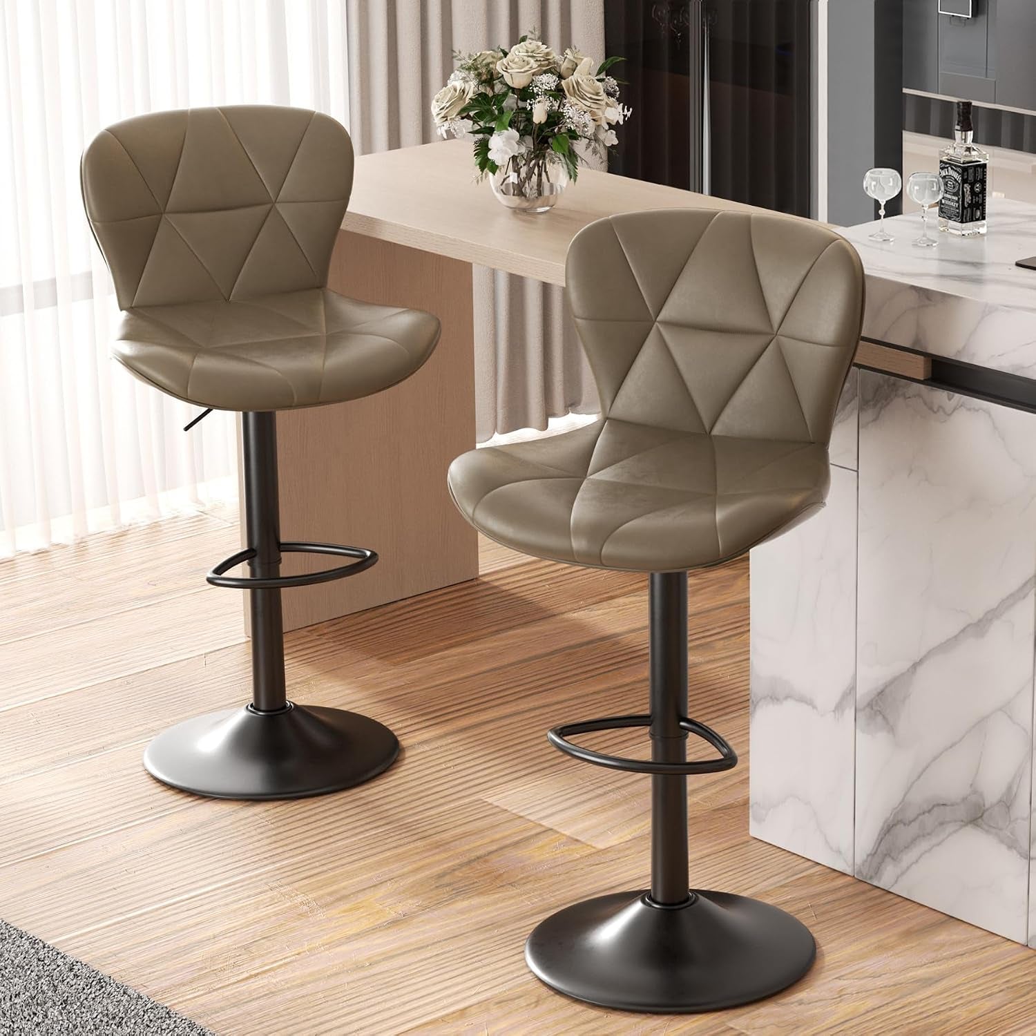 Pair of warm olive-taupe bar chairs viewed from slightly above, showing footrests and round bases