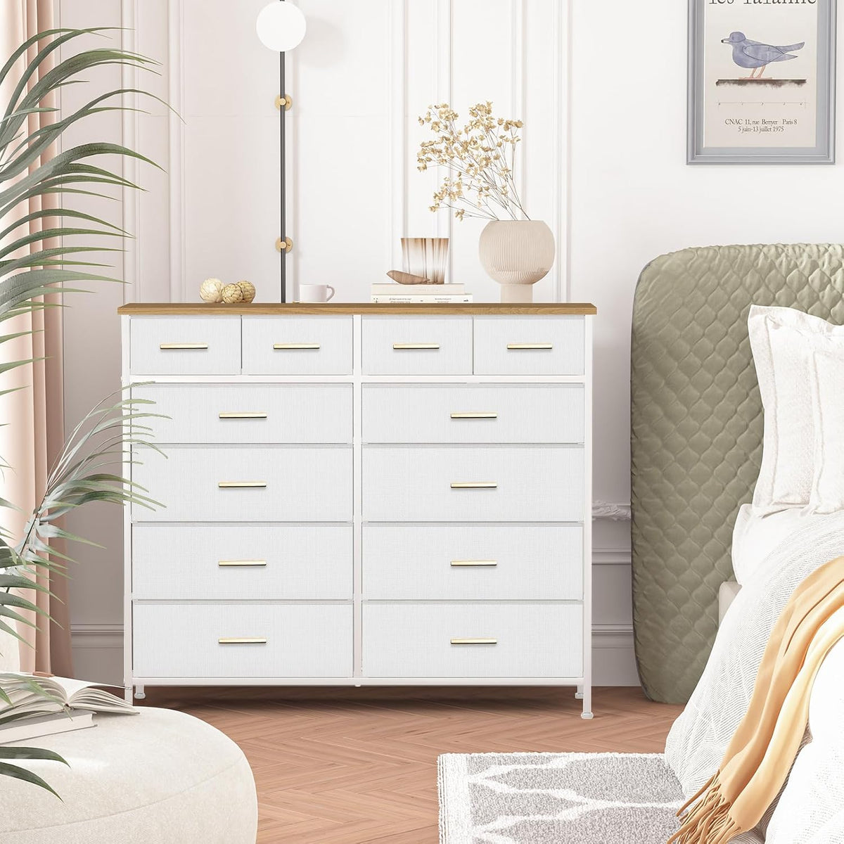 White fabric drawer dresser with wood-tone top beside a bed in a bedroom