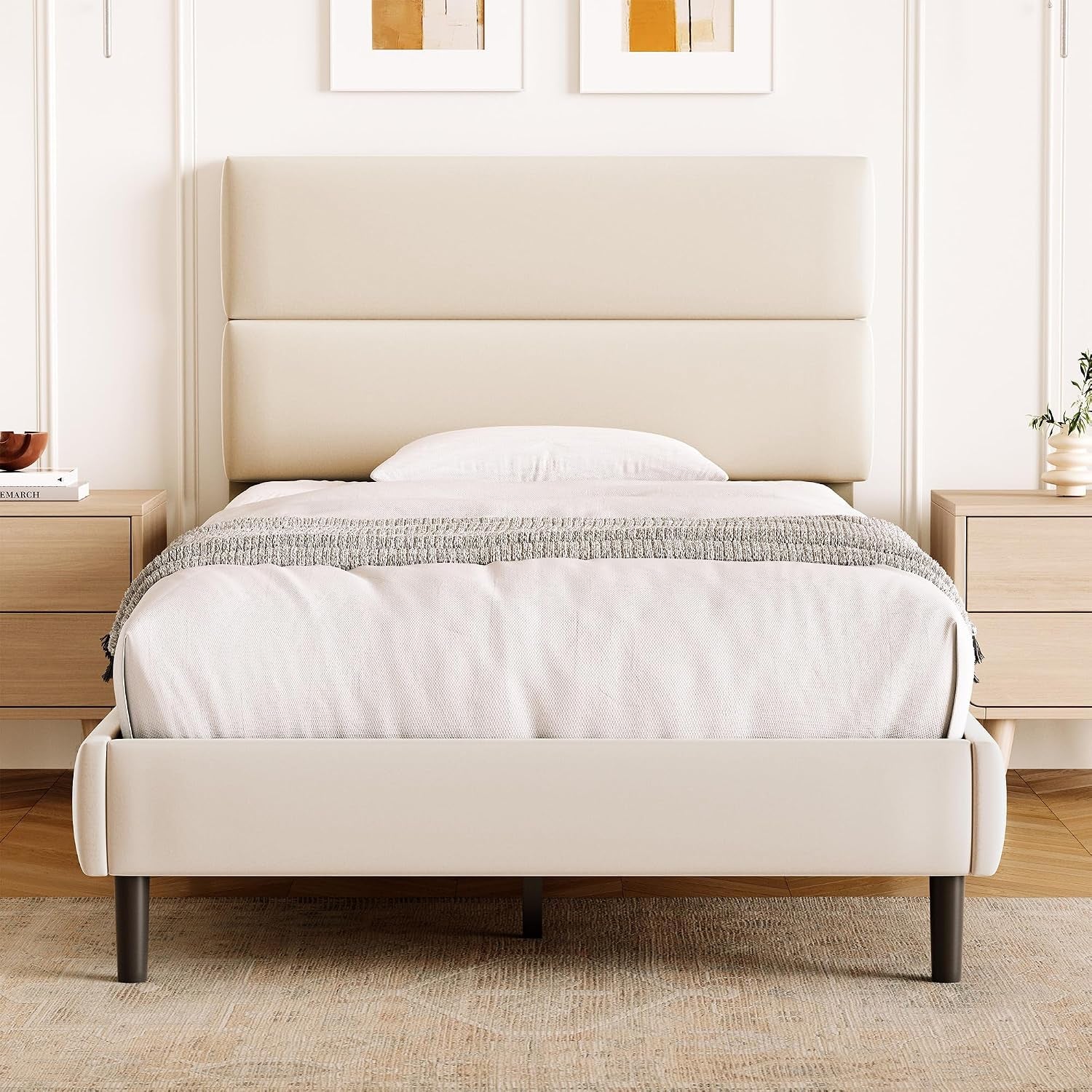 Straight-on room view of a compact cream platform bed with two padded-looking headboard sections.