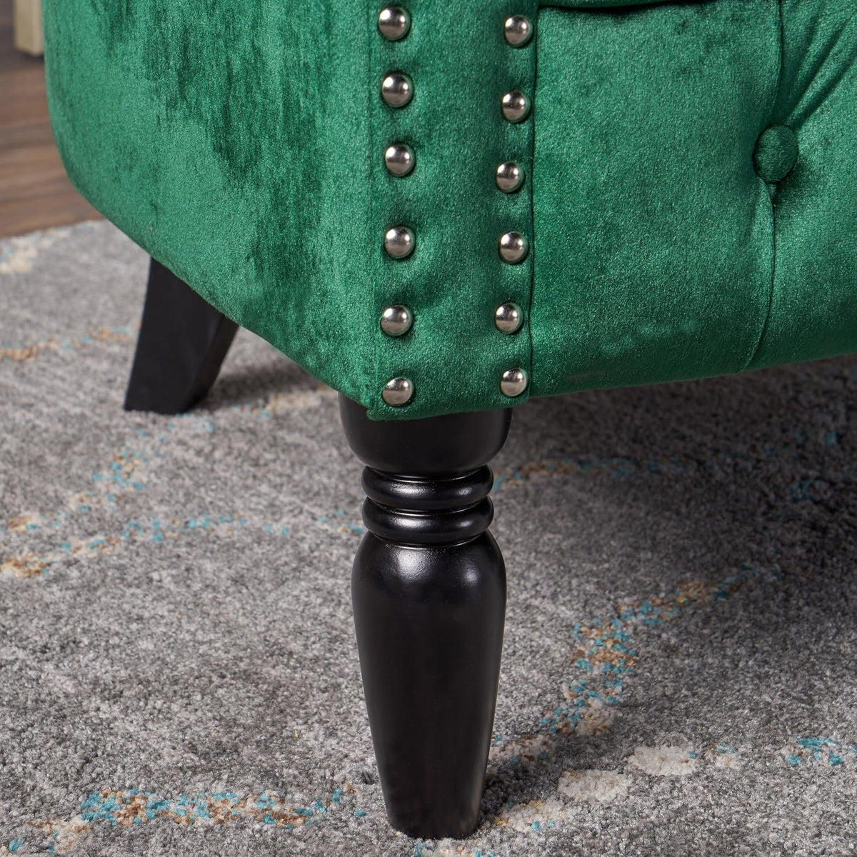 Detail of dark brown turned birch leg and studded trim at the loveseat corner