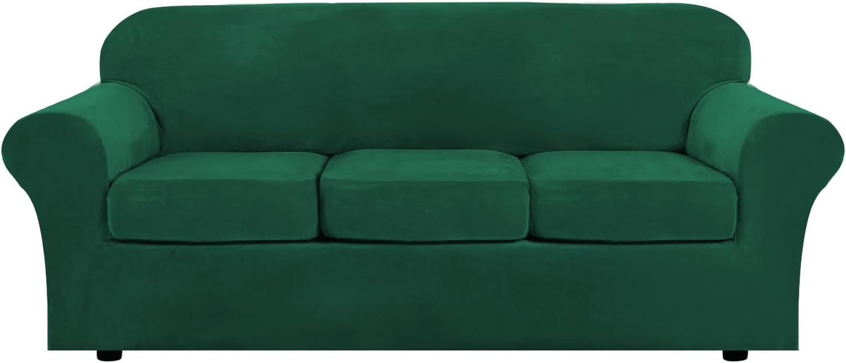Front view of a three-cushion sofa in deep emerald green velvet with rounded arms and short black feet.