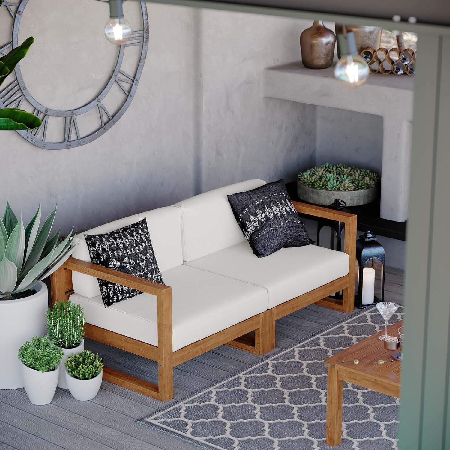 View through a doorway of a teak loveseat with white cushions, rug and tabletop with glasses