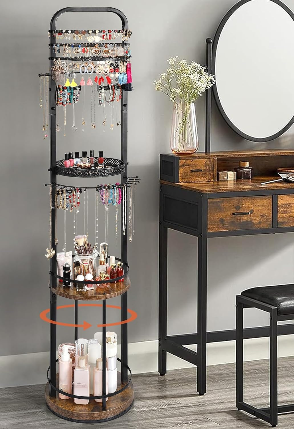 Black three-tier rotating jewelry stand shown with an orange rotation arrow beside a wooden vanity.