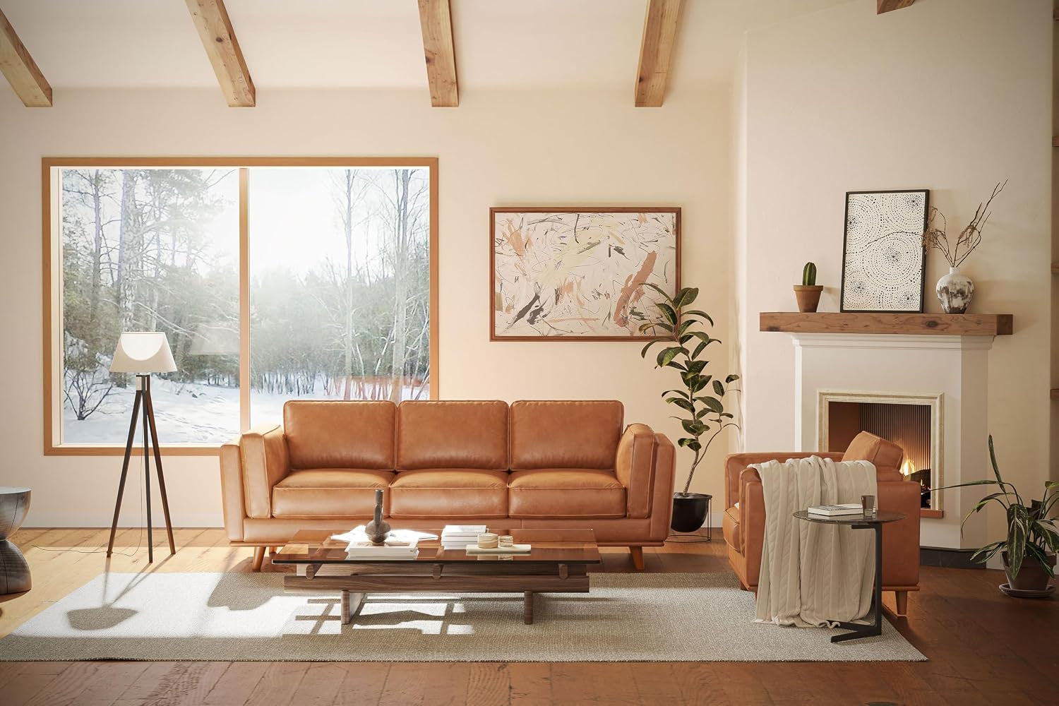 Wide living room scene showing the cognac leather sofa centered with a matching armchair, coffee table, fireplace and large