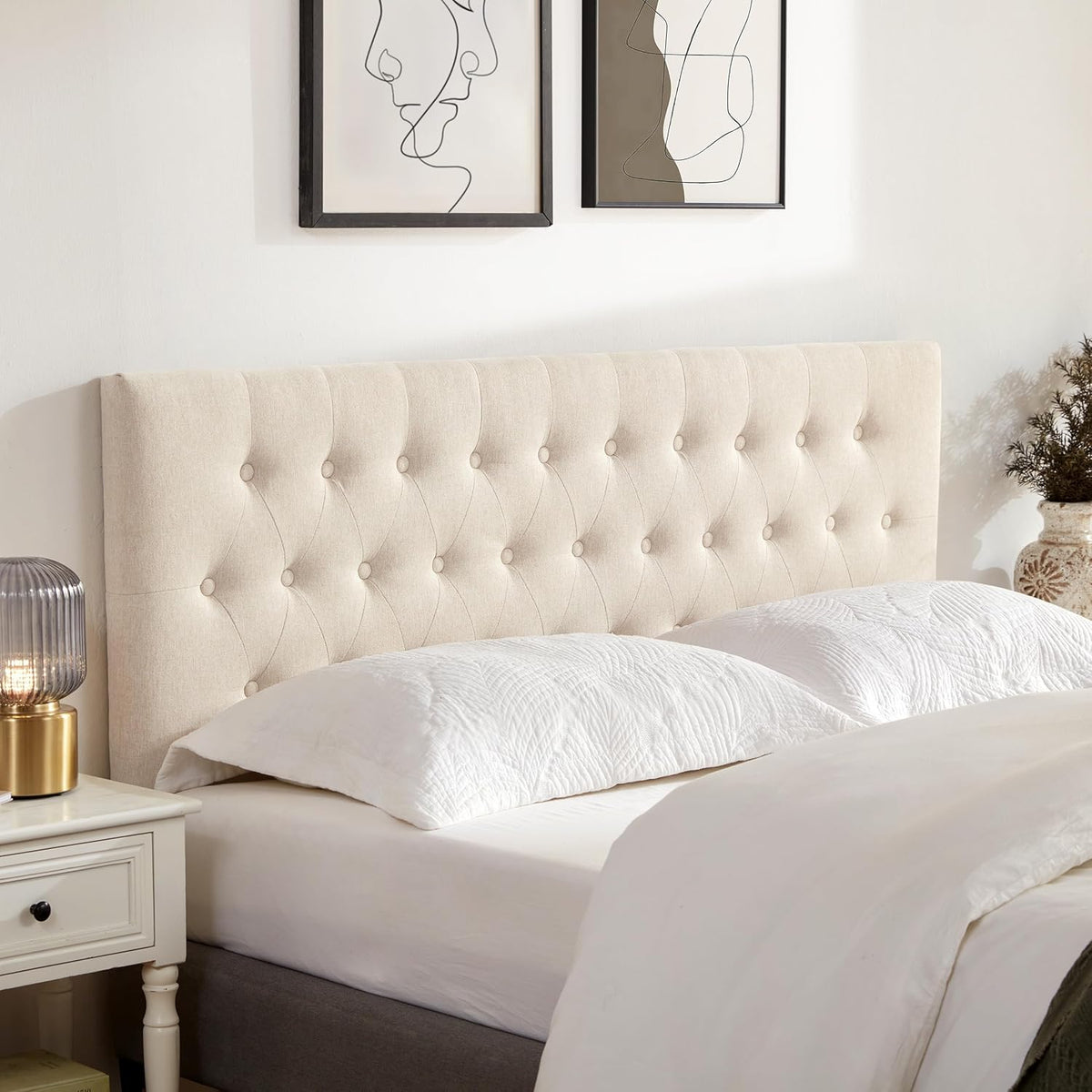 Close-up front view of beige tufted linen headboard showing button tufting with nightstand beside bed
