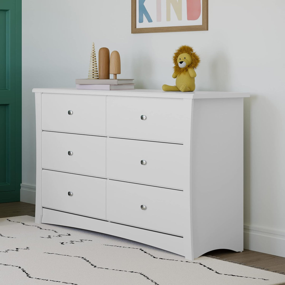 Angled close view of white dresser showing curved side panel and lower drawers with metal knobs