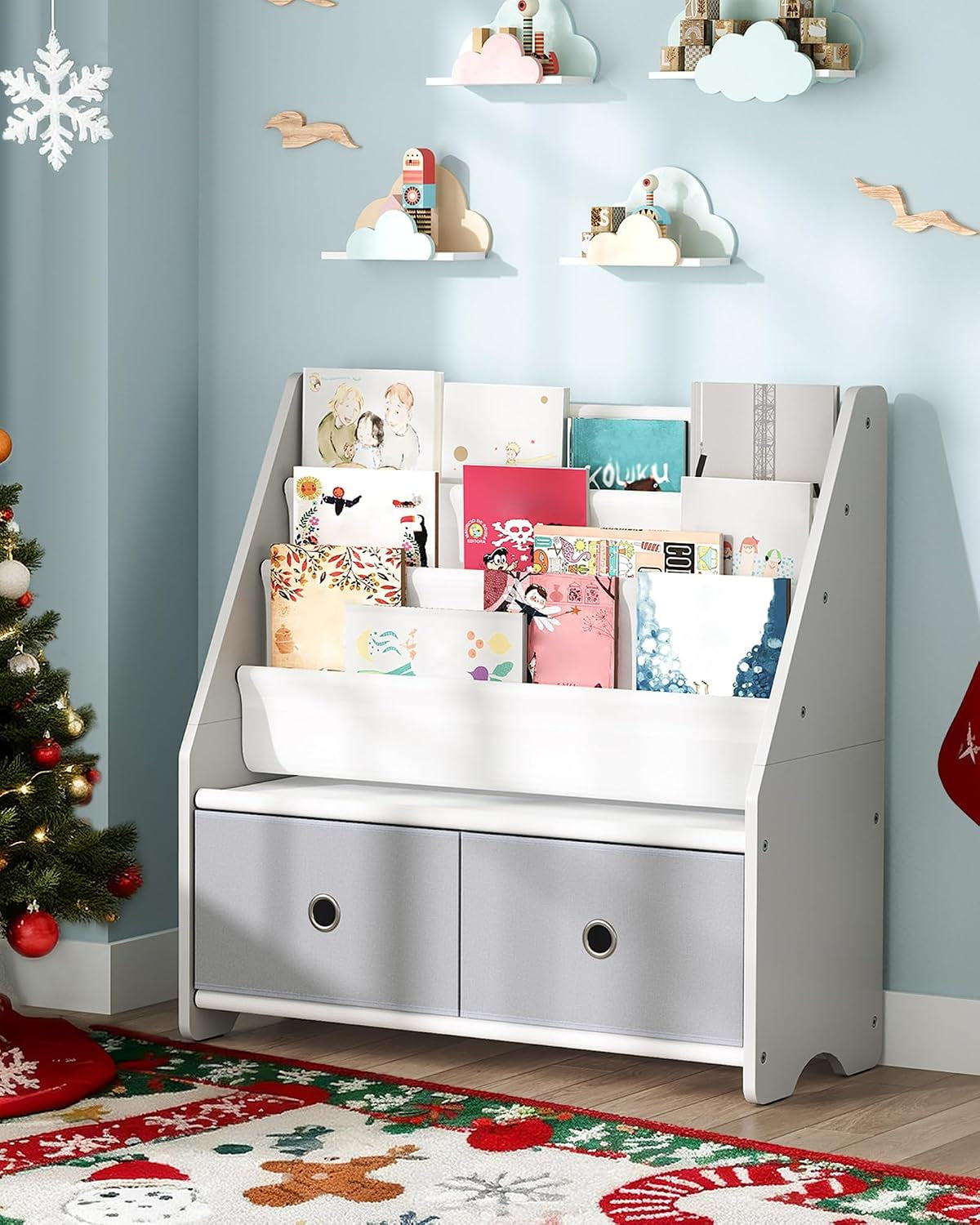 Three-quarter view of a white-and-gray kids' book rack filled with colorful books and fabric drawers next to a decorated