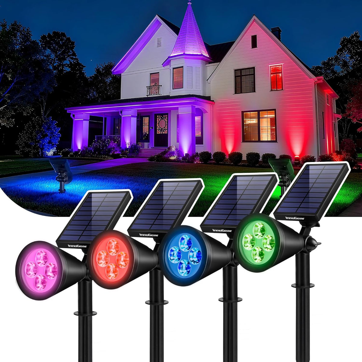 Night view of a house lit by colored uplights and four foreground solar spotlights showing pink, red, blue, and green.