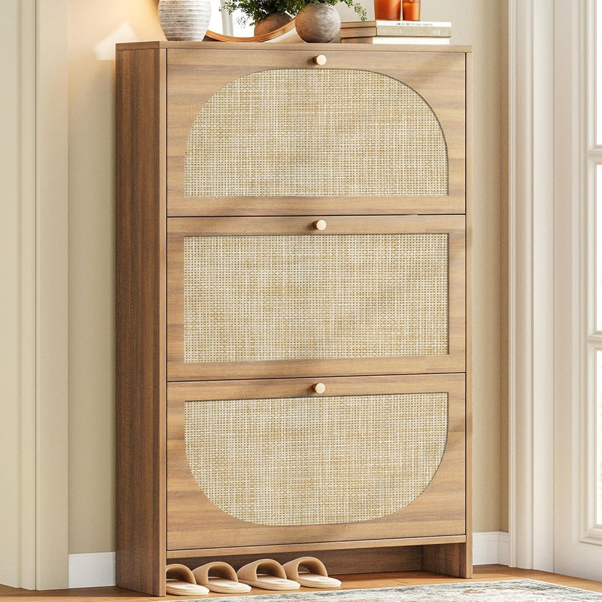 Slim three-tier cabinet in warm brown shown with slippers tucked under the base