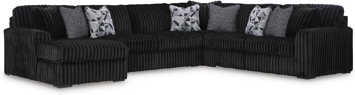 Three-quarter view of a large black ribbed sectional sofa with throw pillows on a white background