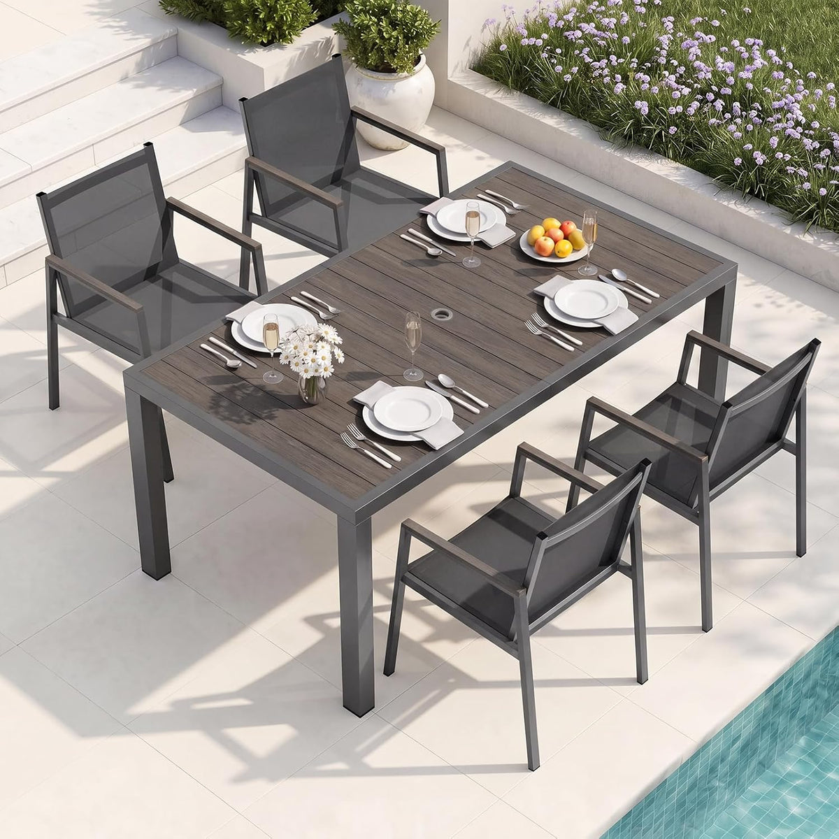 Patio dining scene from above showing a dark-framed table with dark wood top set for four by pool.