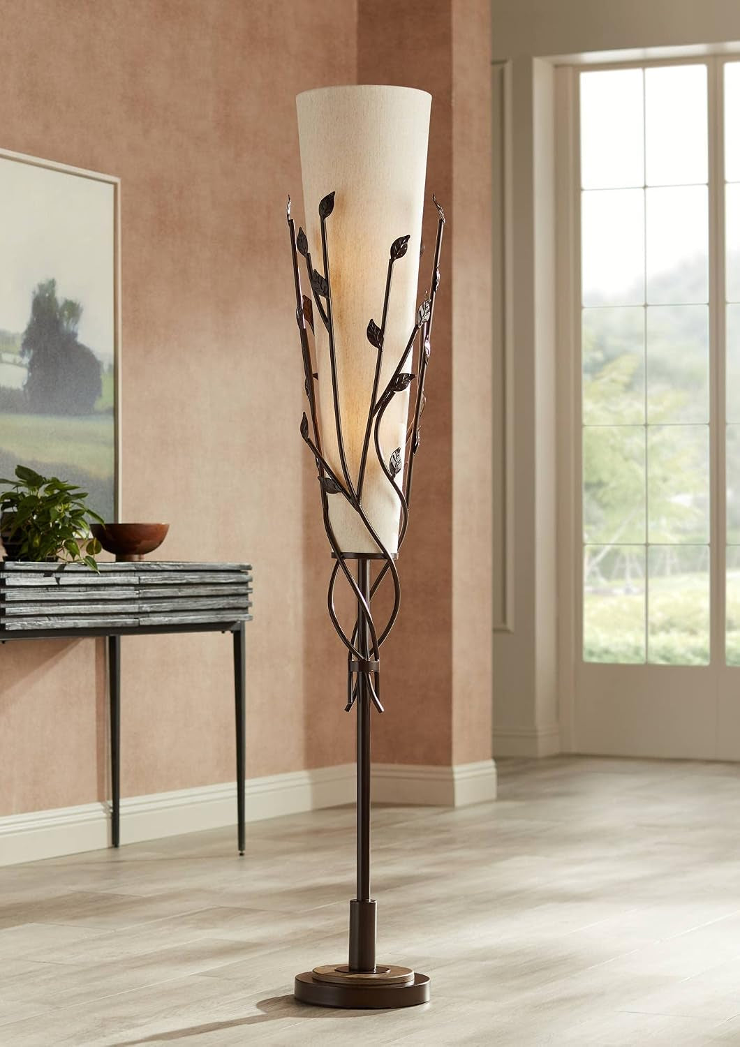 Full-height view of bronze vine floor lamp beside a console and window showing shade and base
