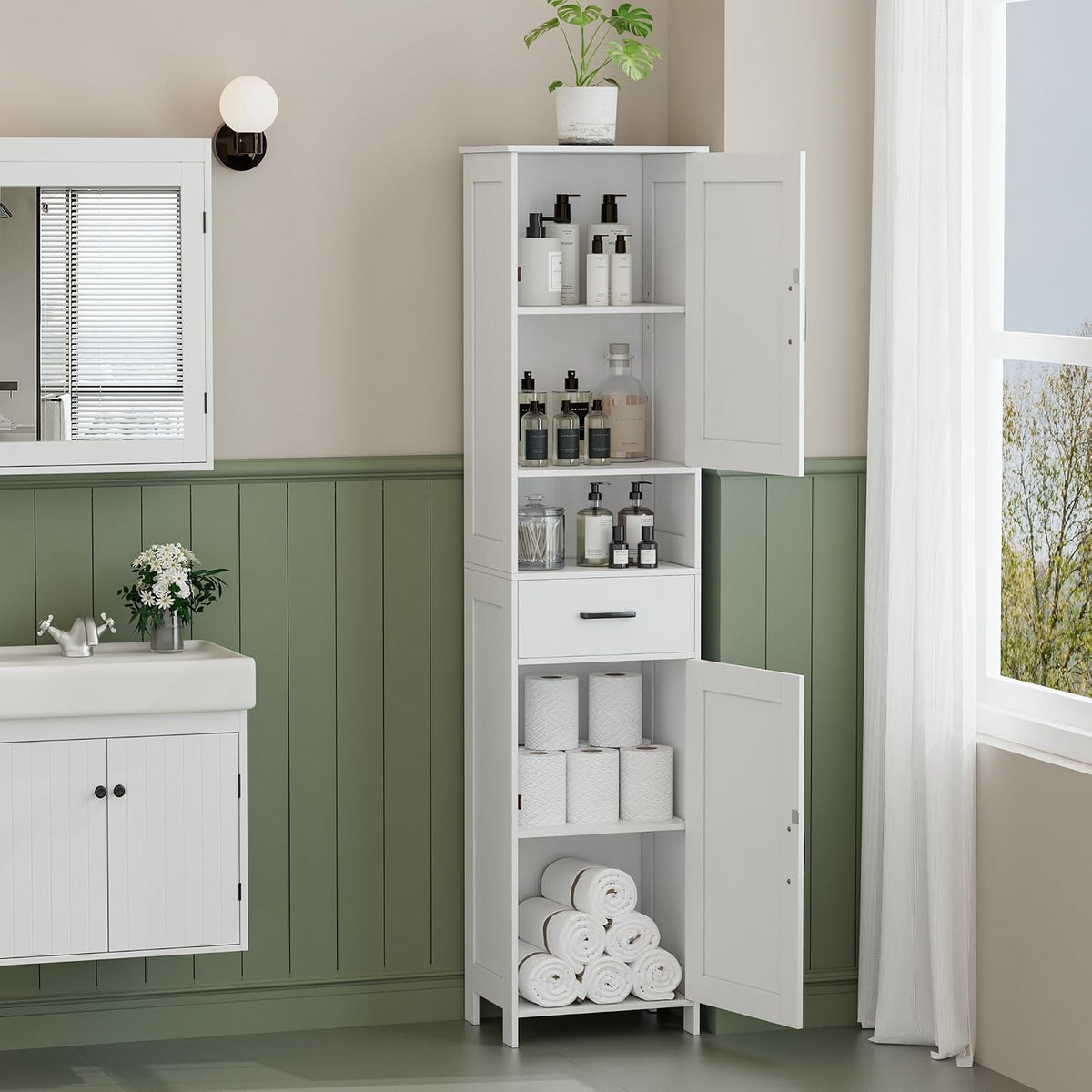Tall white bathroom storage cabinet with doors open, filled with toiletries and rolled towels by a sink
