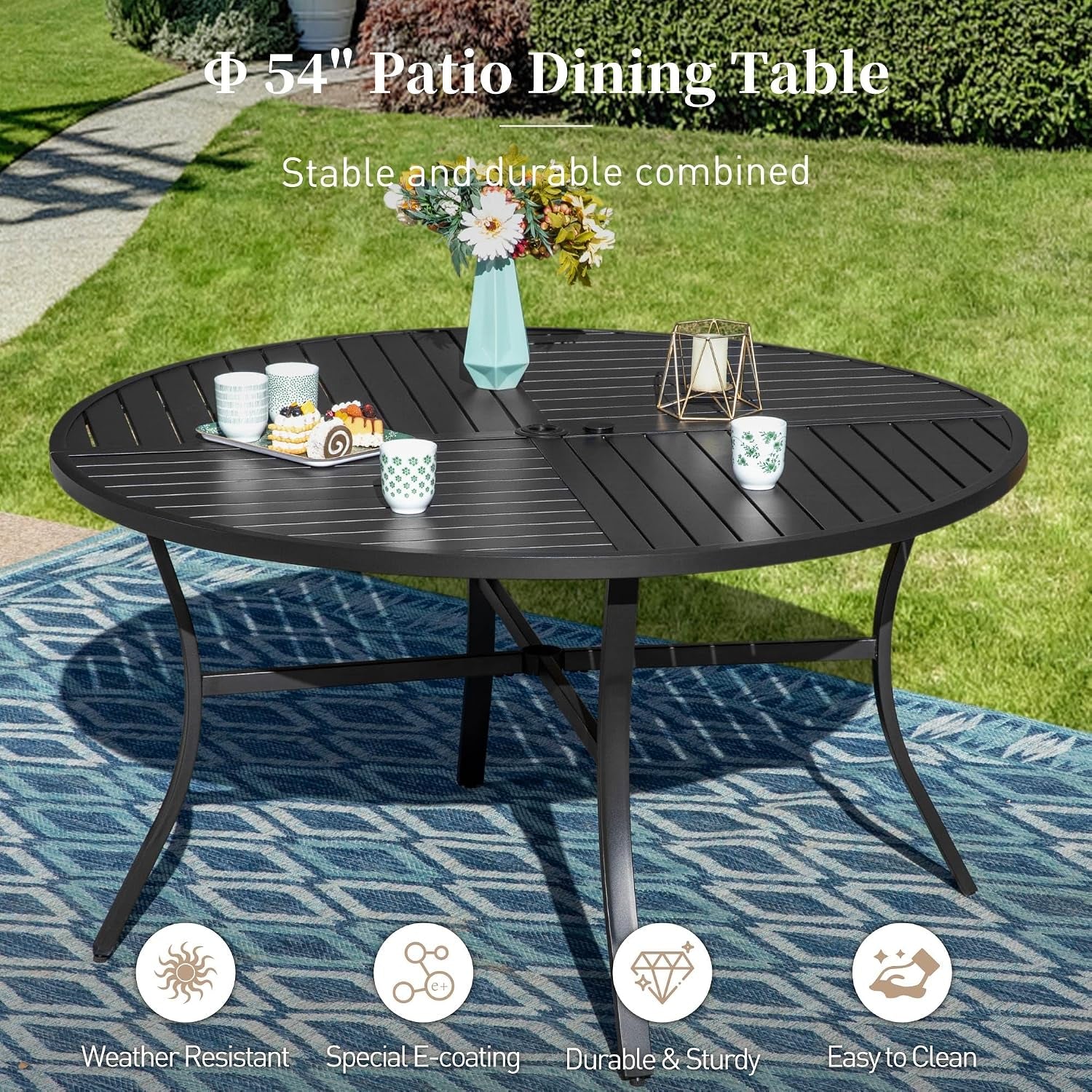 Round metal patio table on a lawn setting with a vase, cups and small plates in a lifestyle scene