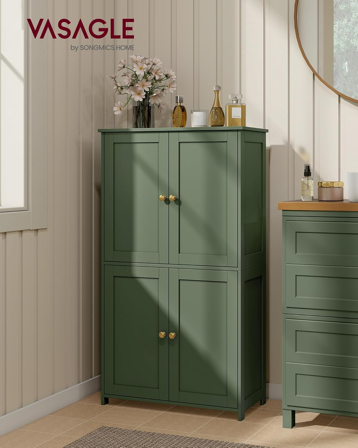 Forest green shaker-style storage cabinet closed and styled in a light bathroom setting with decorative items on top