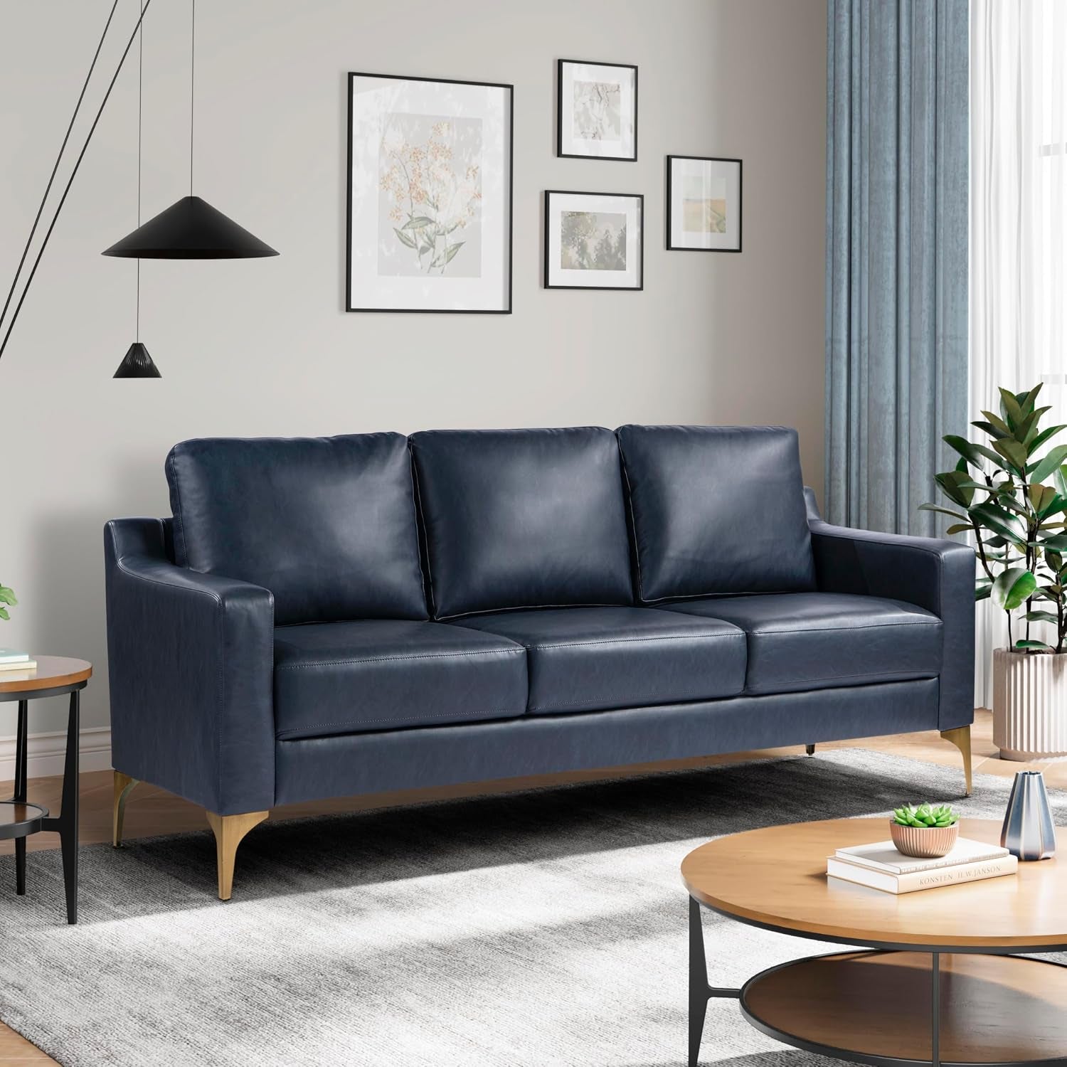 Three-seat navy faux-leather sofa with slim arms and gold tapered legs in a living room.