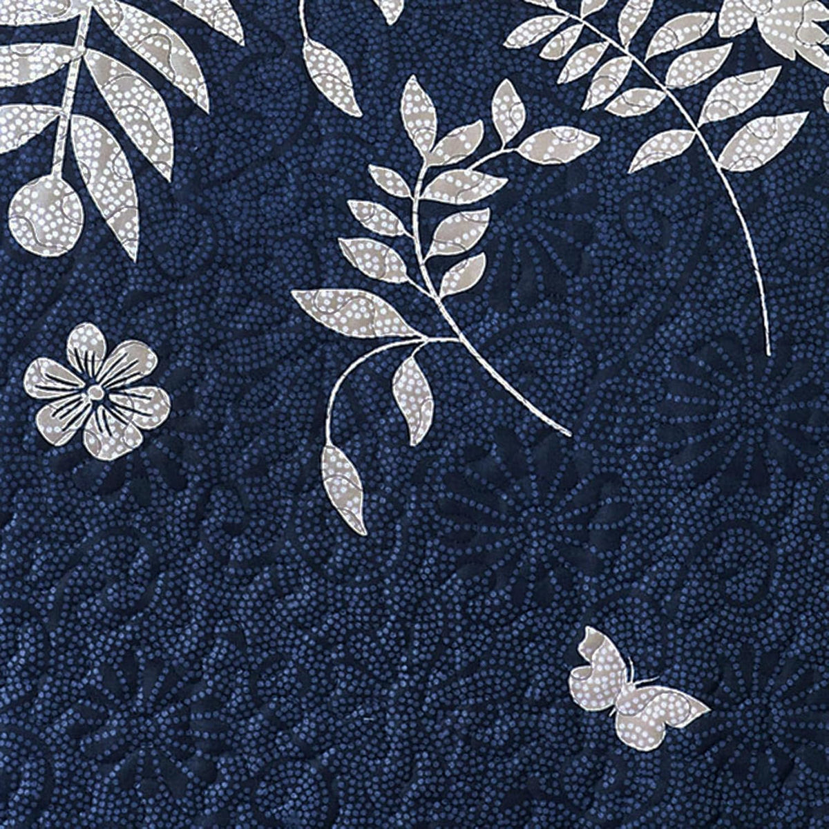 Close fabric detail showing dotted leaf-and-butterfly botanical print on a deep navy background