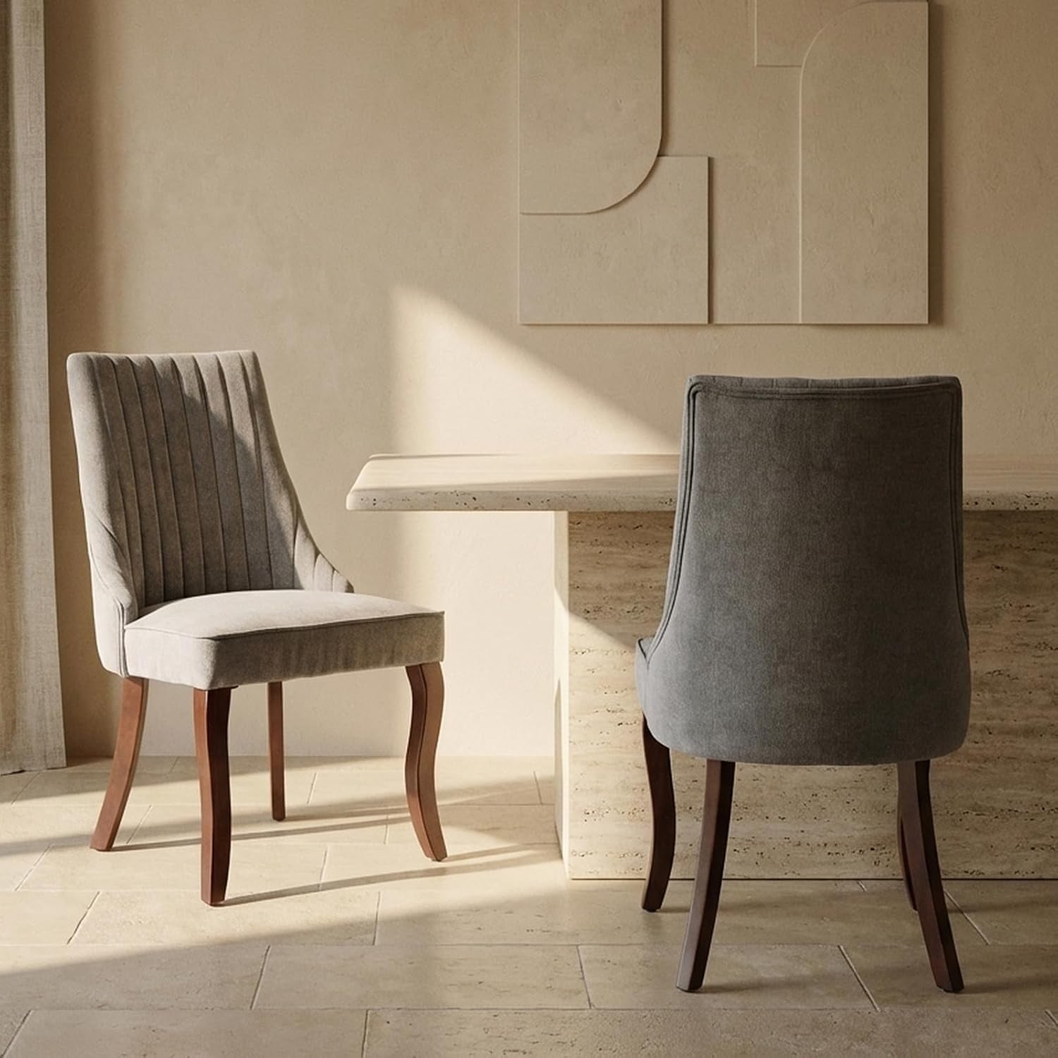 Gray upholstered dining chair pair, one facing forward and one showing the curved back