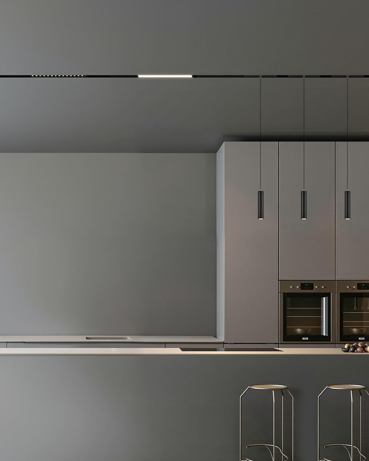 Minimal kitchen with long recessed black track and slim light segment on the ceiling, plus four hanging pendant lights over
